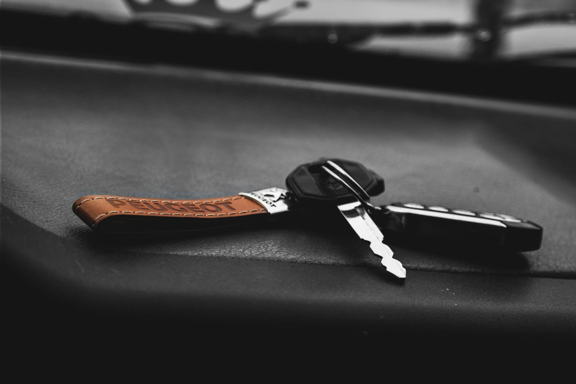 Car key and remote fob on a dark dashboard